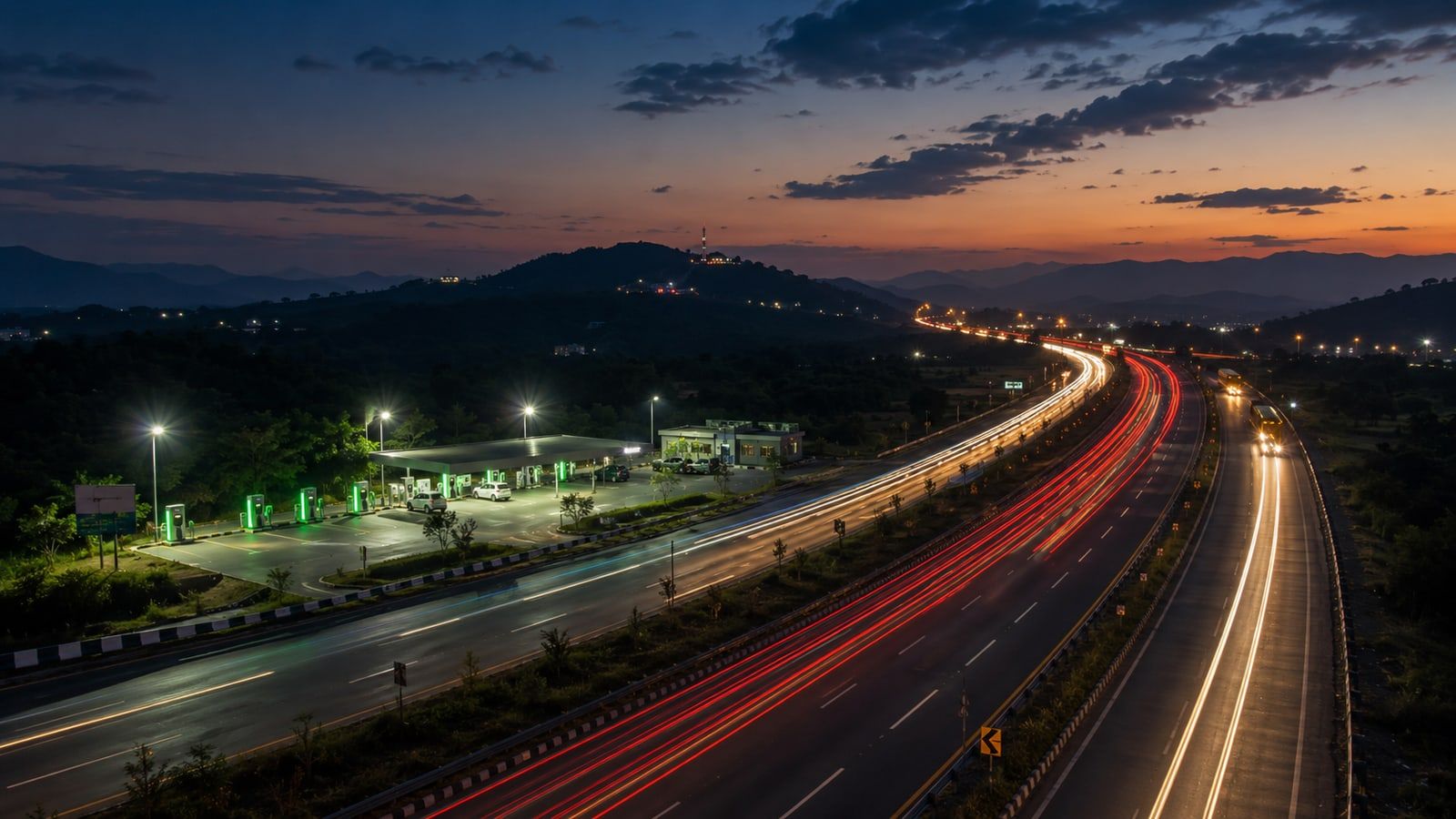 Light trails from evening traffic streaking along an Indian highway corridor at dusk