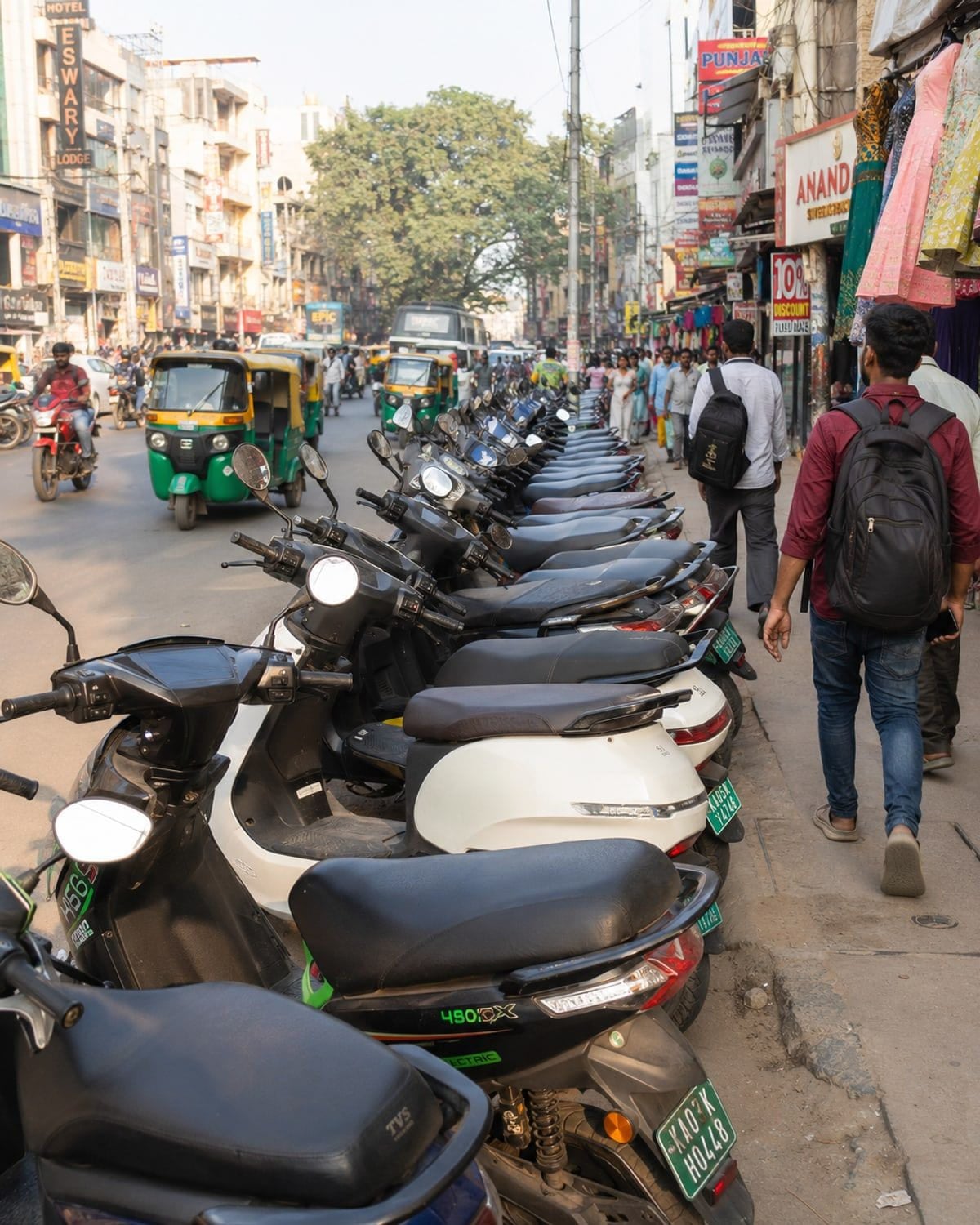 Electric two-wheelers moving through a busy Indian city street